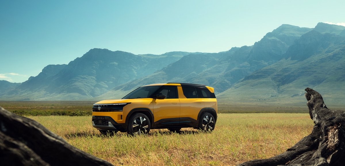 Tata Sierra parked in an open field with mountains behind