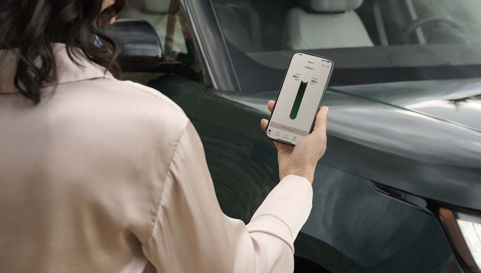 Person checking Range Rover Electric charging status on a smartphone app