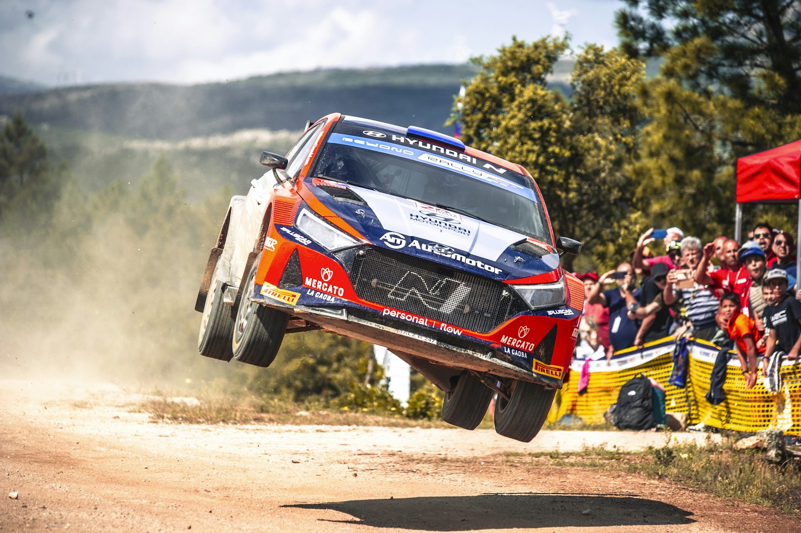 A WRC Rally1 car goes airborne on a gravel stage