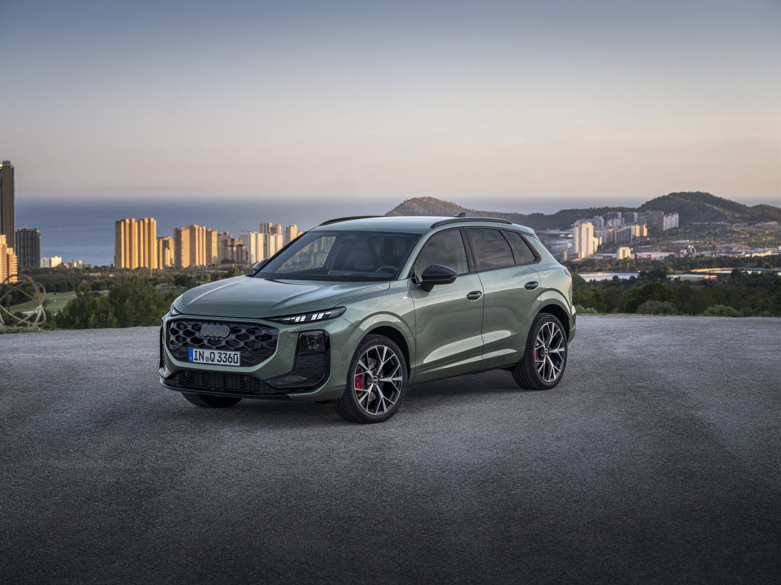 New Audi Q3 three-quarter front view with a city skyline in the background