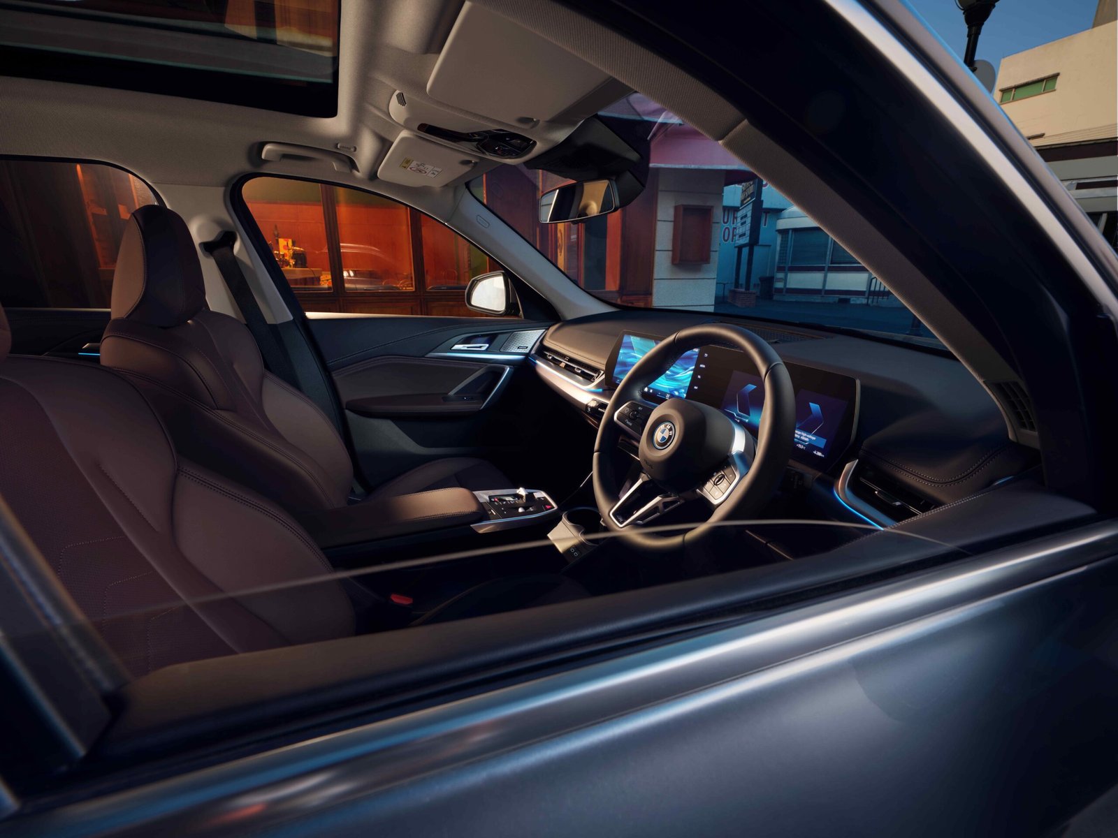 Interior of the BMW iX1 Long Wheelbase showing its illuminated dashboard