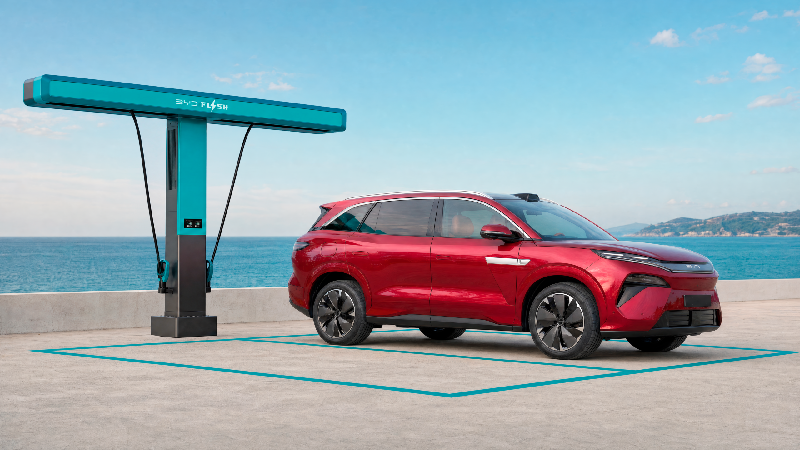 BYD Atto 8 parked at a BYD FLASH Charging station by the coast