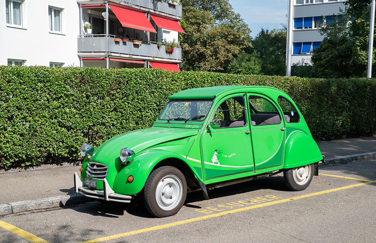 A classic green Citroen 2CV parked on a residential street