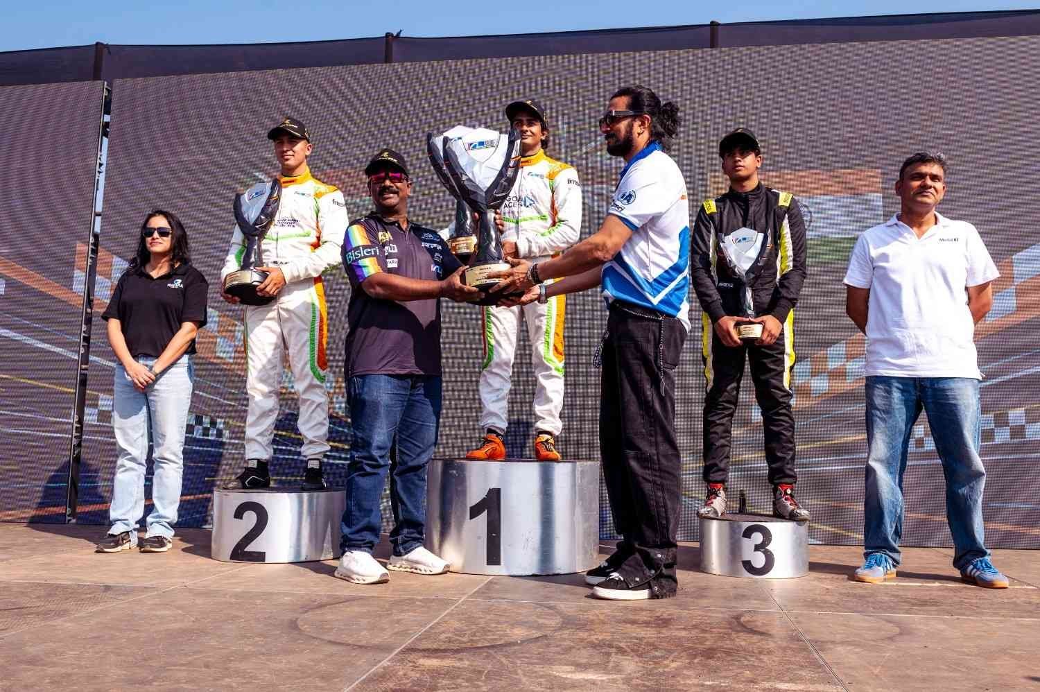 Drivers celebrate on the podium with trophies at an F4 Indian Championship round