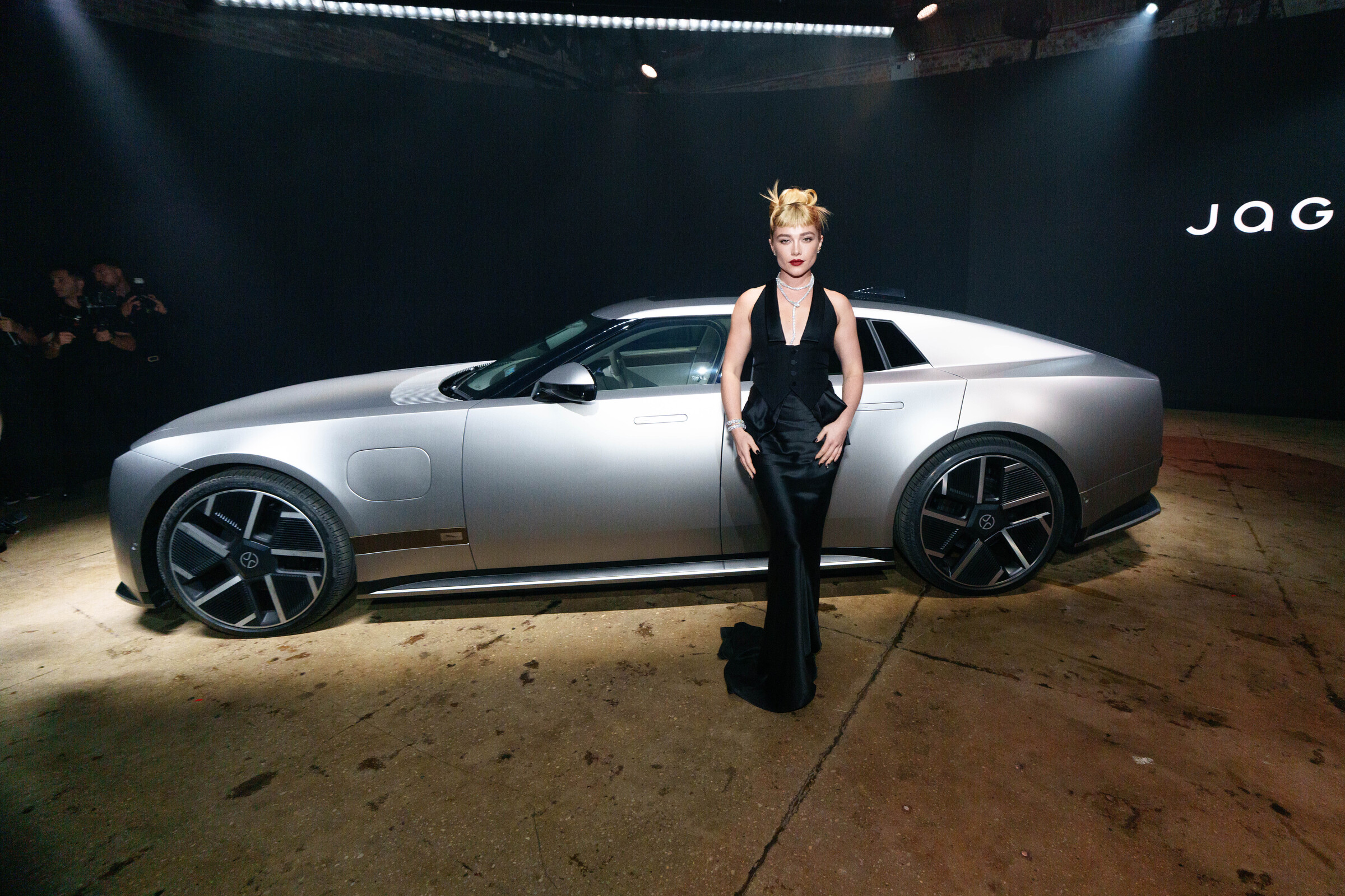 Florence Pugh standing beside the Jaguar Type 01 at its New York reveal event