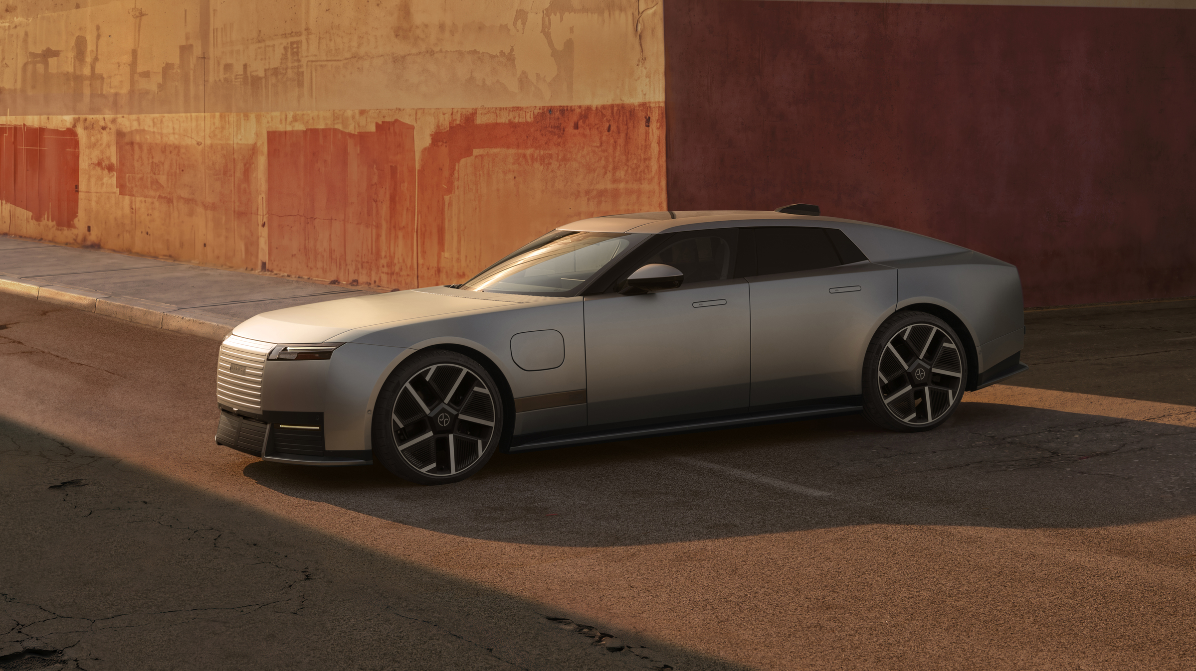 Jaguar Type 01 electric GT parked against a weathered urban wall at golden hour