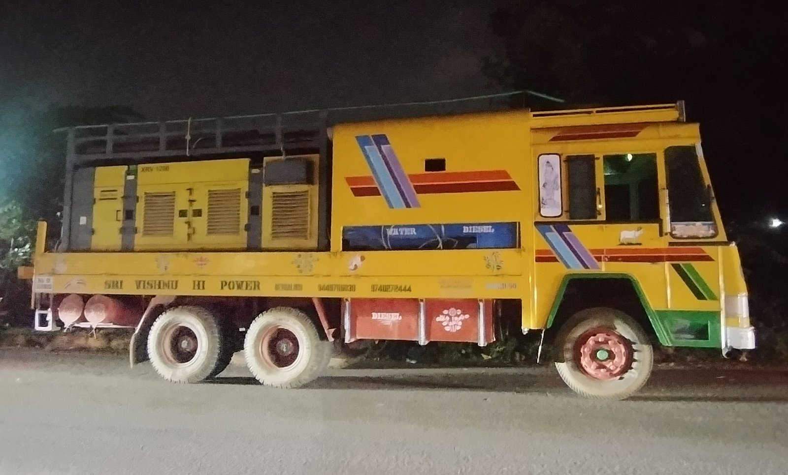Loaded commercial trucks parked on an Indian road at night