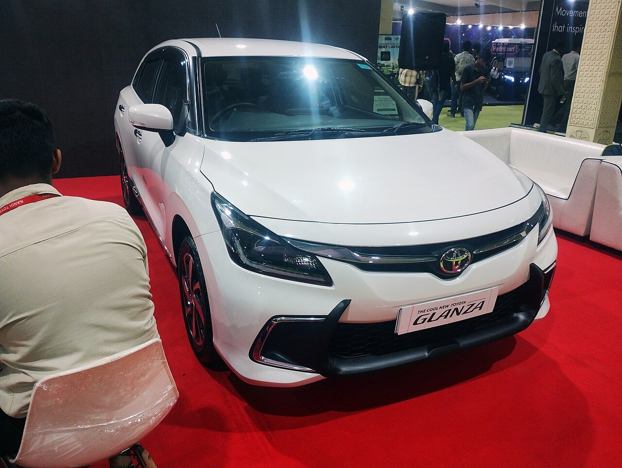 Toyota Glanza on display at an auto show, pre-facelift model shown