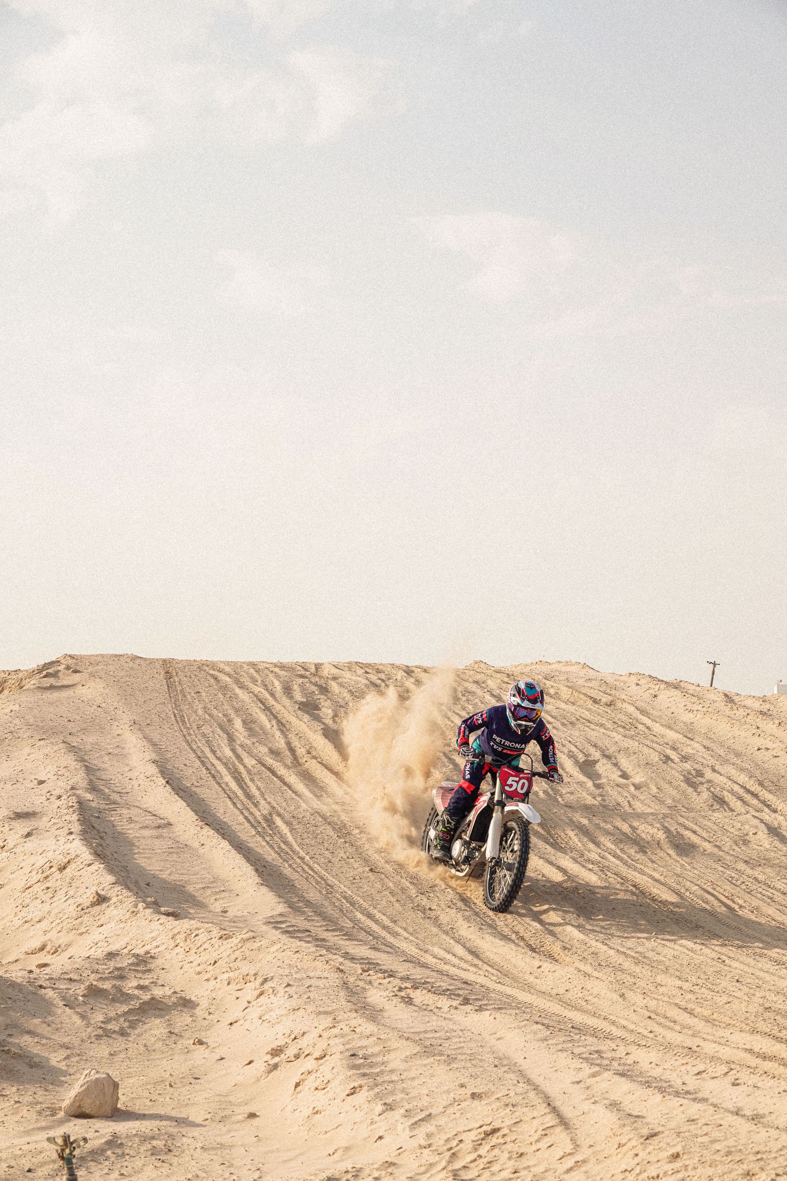 TVS Racing liveried motorcycle rider on a desert dune